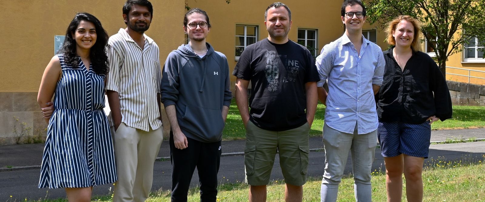 Members of the MDPPML group standing together outside a university building